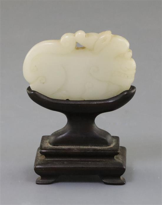 A Chinese white jade lion-dog plaque, 18th century, 6cm, wood stand